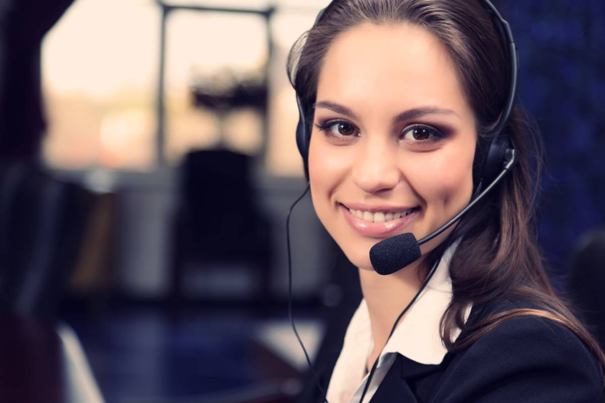 Female Call Center employee smiling at work while wearing a headset